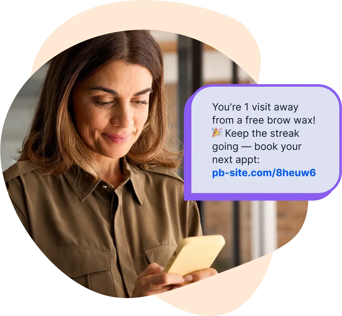 A salon client reading a loyalty reward text on her phone